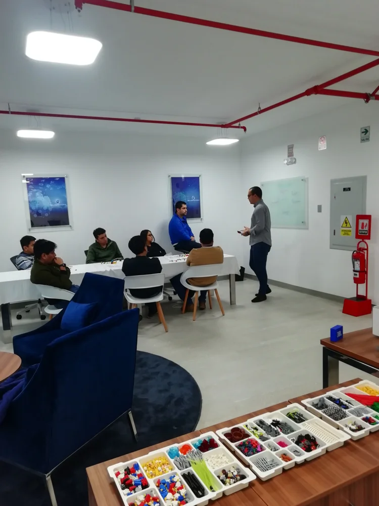 Sesión de trabajo en equipo con materiales LEGO sobre una mesa